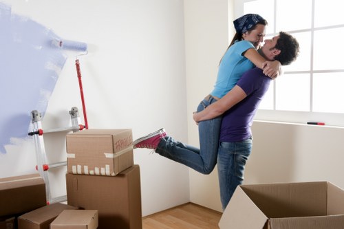 Movers carrying items from an Eastfinchley flat with stair access