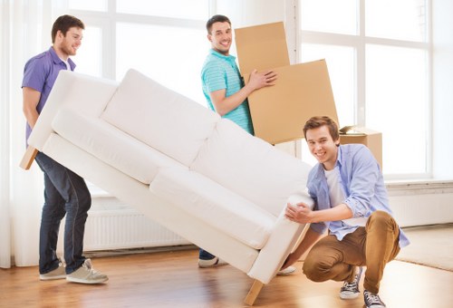 Packed moving boxes and protected furniture ready for a house move